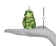 Green sitting frog ornament, 3 inches high, shown resting on a person's palm for scale.