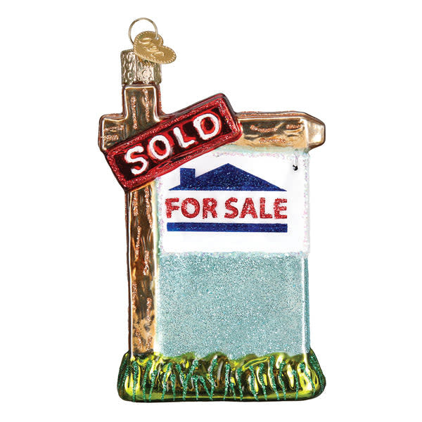 Glass ornament shaped like a sold real estate sign with silver finish and hand-painted glitter.