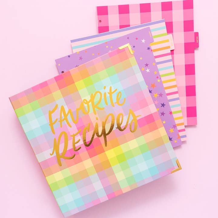 Gold foil recipe binder with eight colorful patterned tabs inside a three-ring system.