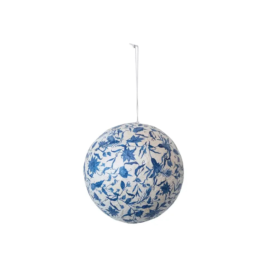 Blue and cream paper mache ball ornament with hand-printed peacock feather and flower pattern.