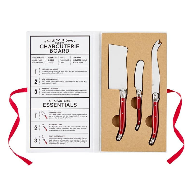 Red handled stainless steel charcuterie knives in a book-shaped cardboard box with recipe pages.