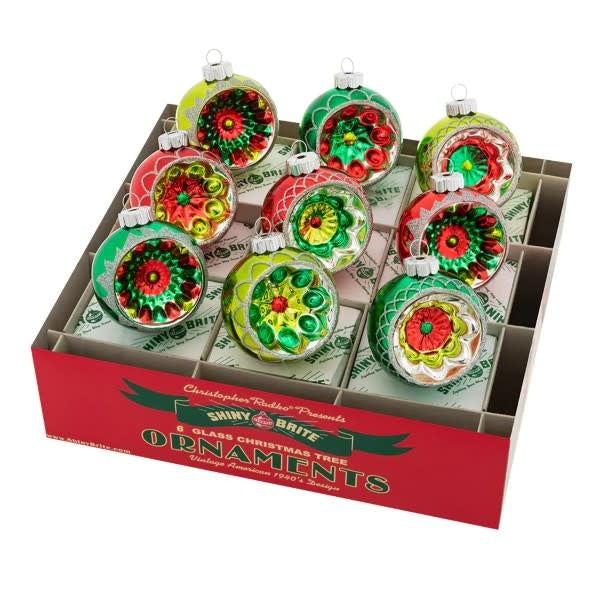 Nine vintage Americana glass reflector rounds with ornate designs in a box.
