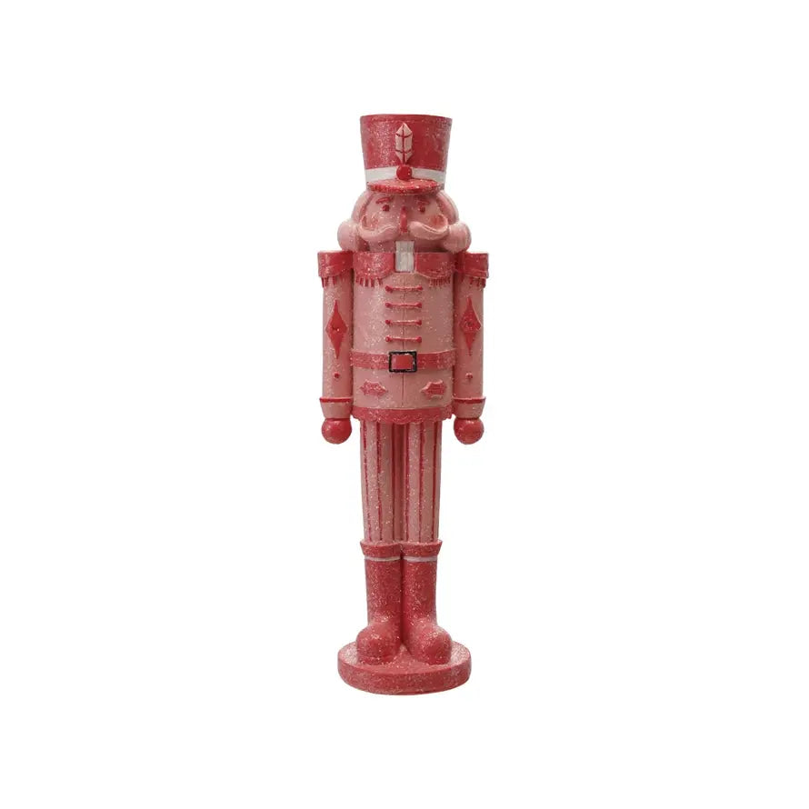 Pink resin nutcracker with red accents and sugar-inspired decorative details.