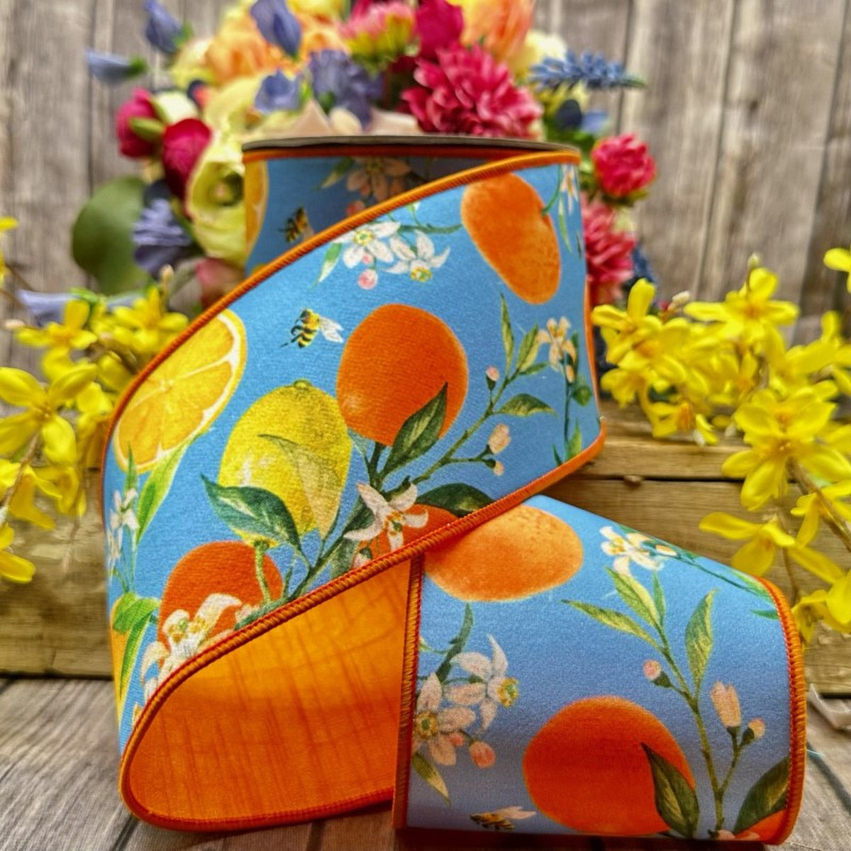 4-inch wide Dupion ribbon featuring a watercolor citrus blossom pattern in blue, orange, and yellow.