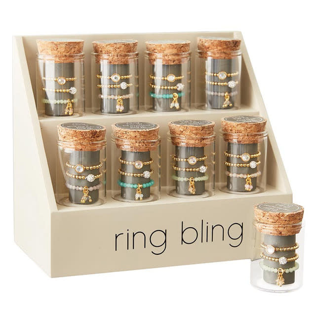 Brass stretch ring set with glass accents displayed in a cork-lined jar