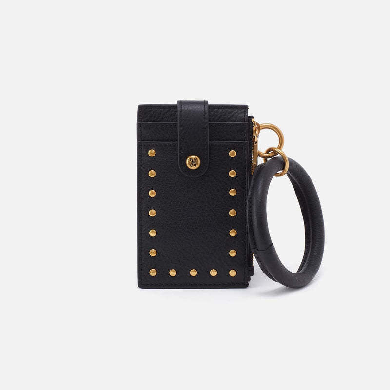 Black leather ring wristlet with brushed brass hardware, card slots, zip pocket, and removable handle.