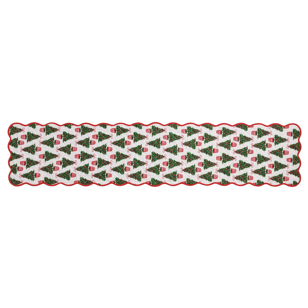 Quilted white table runner with a pattern of green Christmas trees and a red scalloped border.