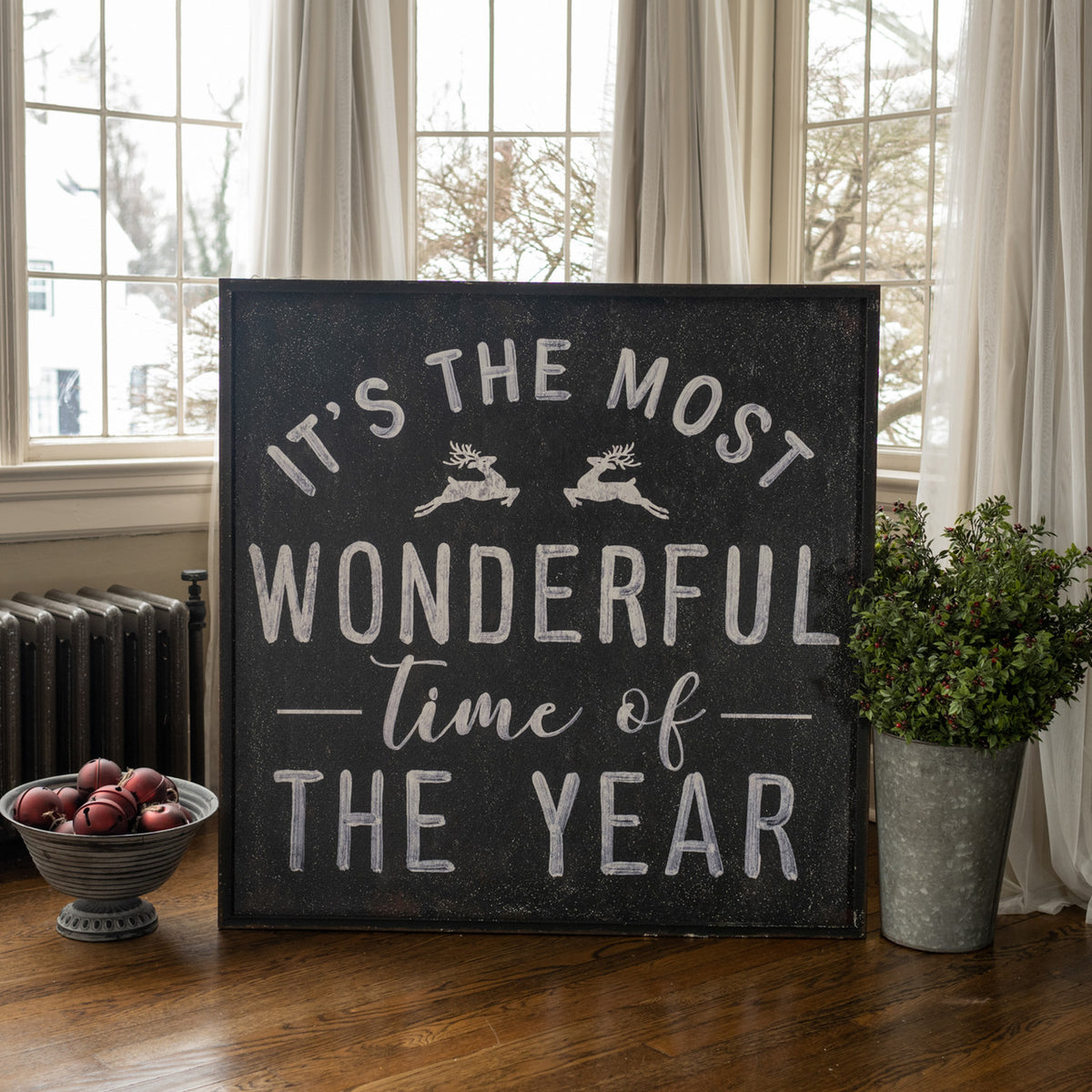 Metal wall sign with wood frame displaying black text on white background reading 'Most Wonderful Time' in a decorative font.