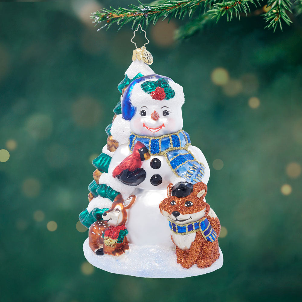 Wintery Pals glass ornament featuring a snowman with a cardinal, fox, and deer by a snowy tree.