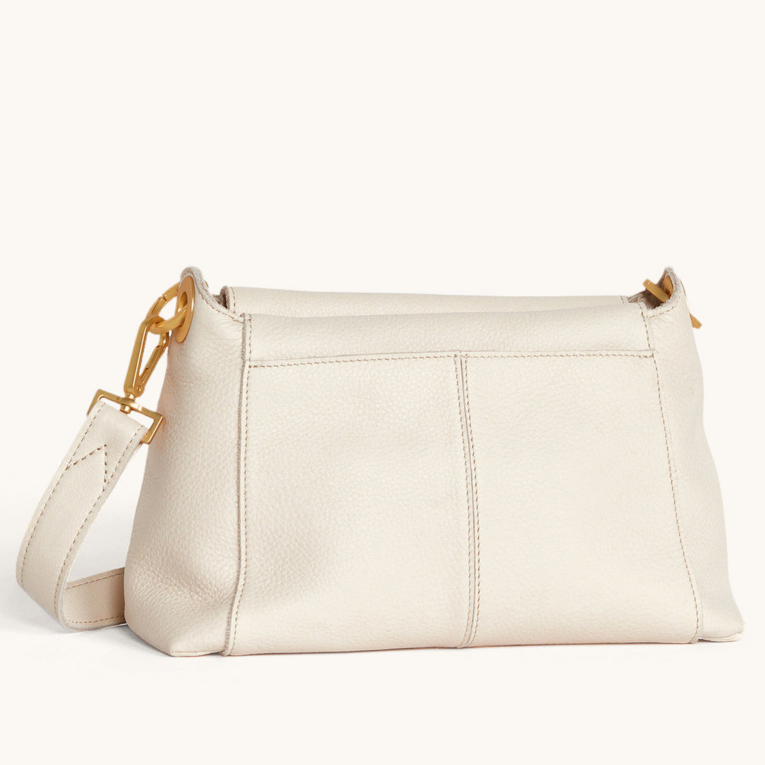 Bryant Med crossbody bag in white Calla Lily exterior with brushed gold hardware and interior zip pocket.
