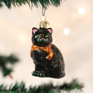 Black cat Halloween ornament with white whiskers and green eyes.