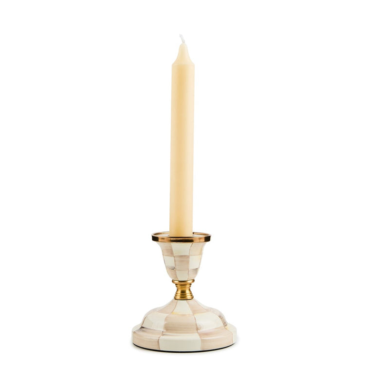 Mackenzie Childs Mocha Check short candlestick with brass accents and a cream taper candle.