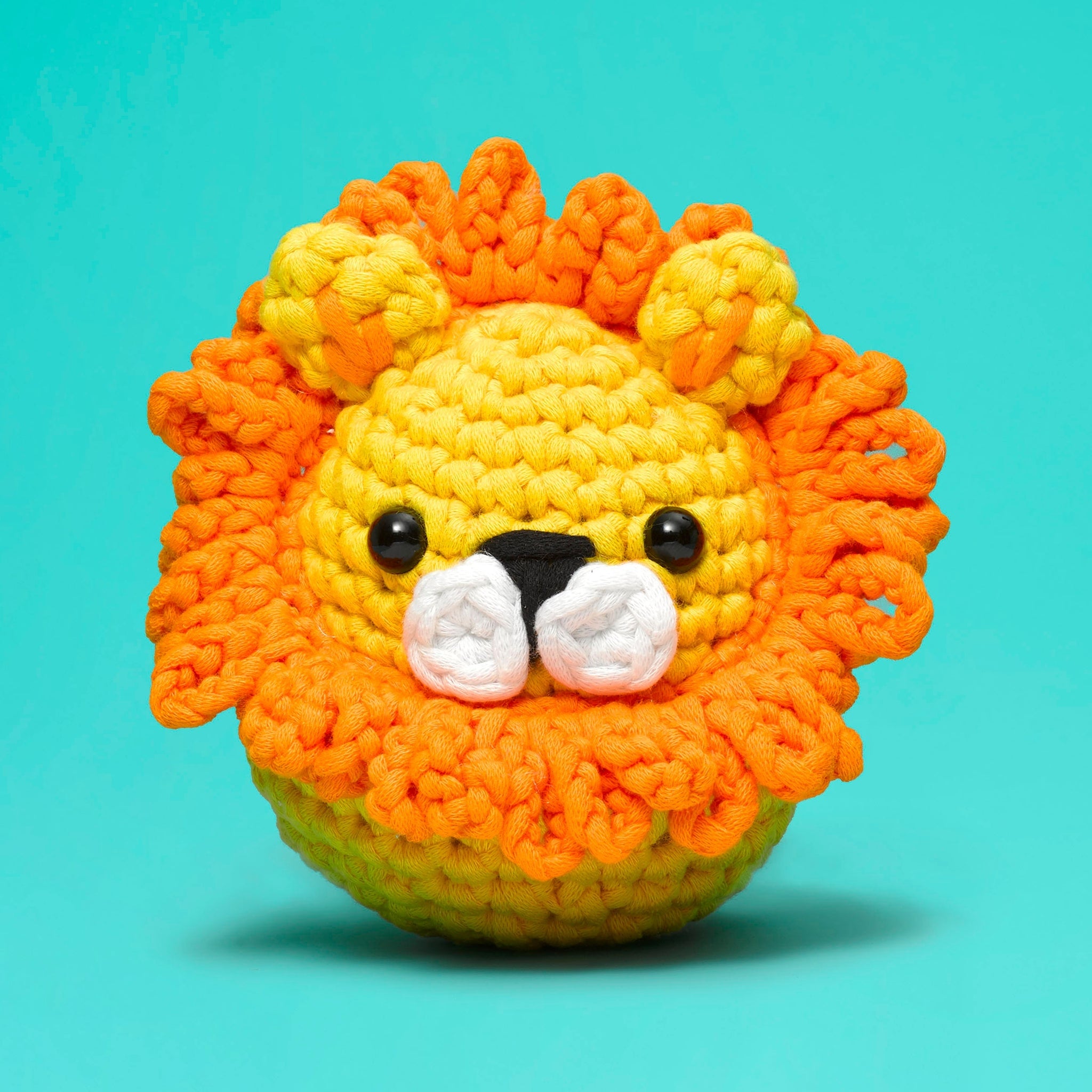 Sebastian the Lion crochet kit featuring a lion head silhouette with plastic eyes, stuffing, and an ergonomic hook.
