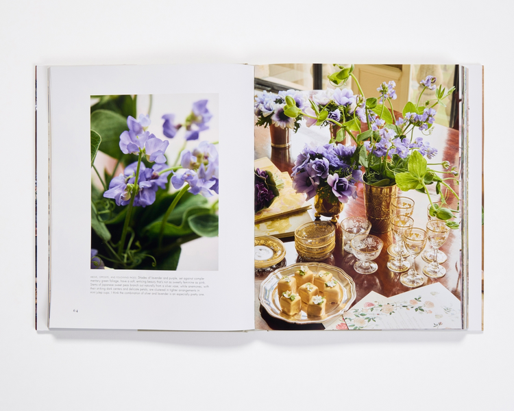 Open pages of Aerin Lauder Living with Flowers book showing purple sweet peas and a table setting.