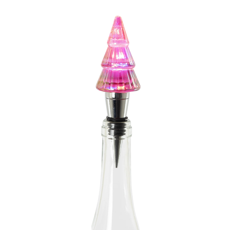Lit pink glass Christmas tree bottle stopper with a silver metal base in a clear glass bottle.
