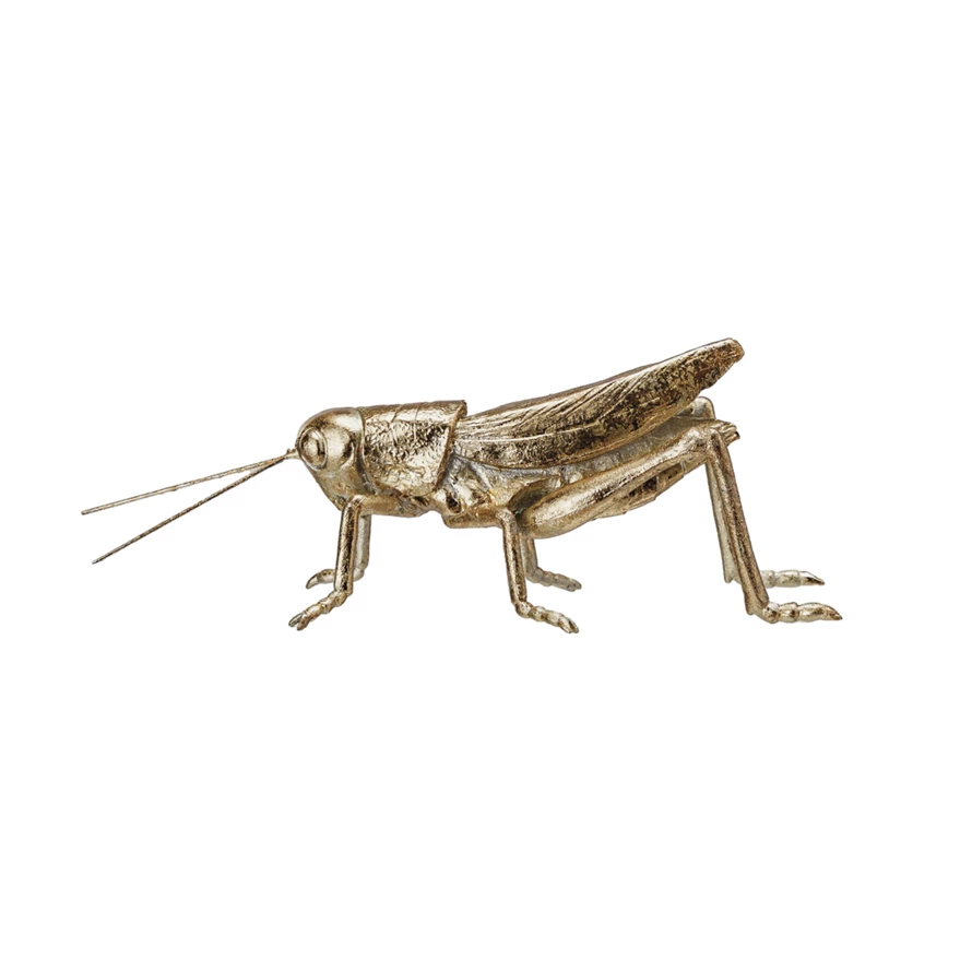 Gold resin and metal grasshopper figurine with a metallic finish on a white background.