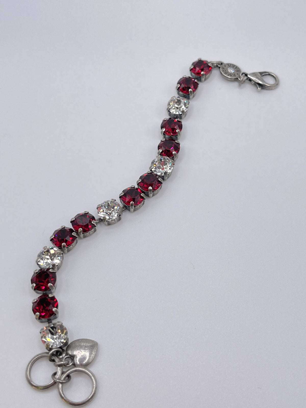Classic Rome bracelet featuring deep red stones with black accents in a sleek metal band.