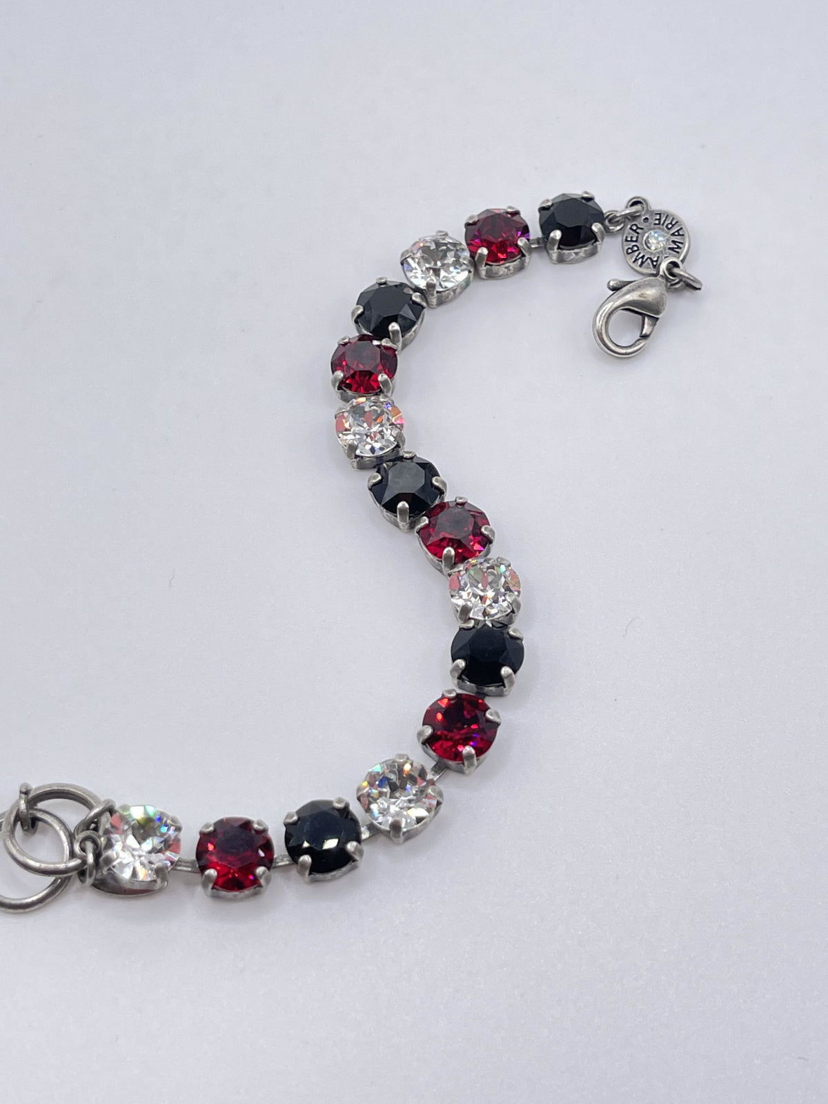 Classic Rome bracelet featuring deep red stones with black accents on a clear band.