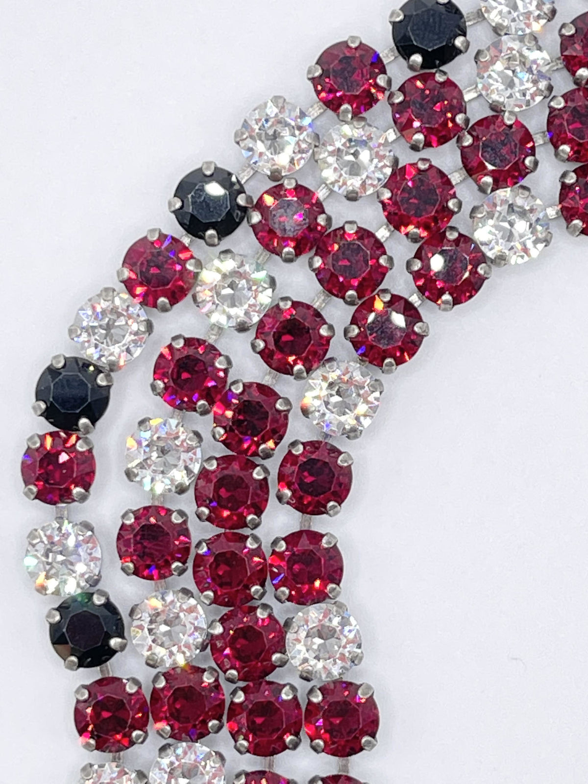 Classic Rome bracelet featuring deep red stones with black accents on a clear band.