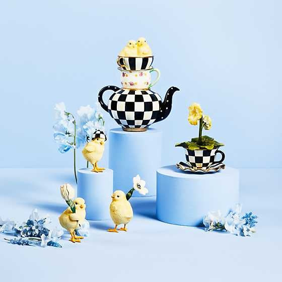 Set of three hand-painted resin garden chick figurines in pastel colors holding tulips and daisies.