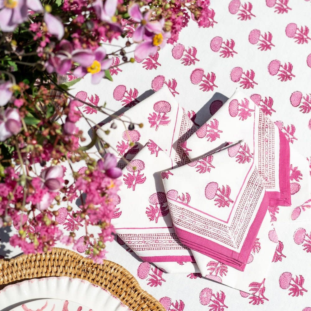 Set of four square cotton napkins with a pink rose motif on white background.