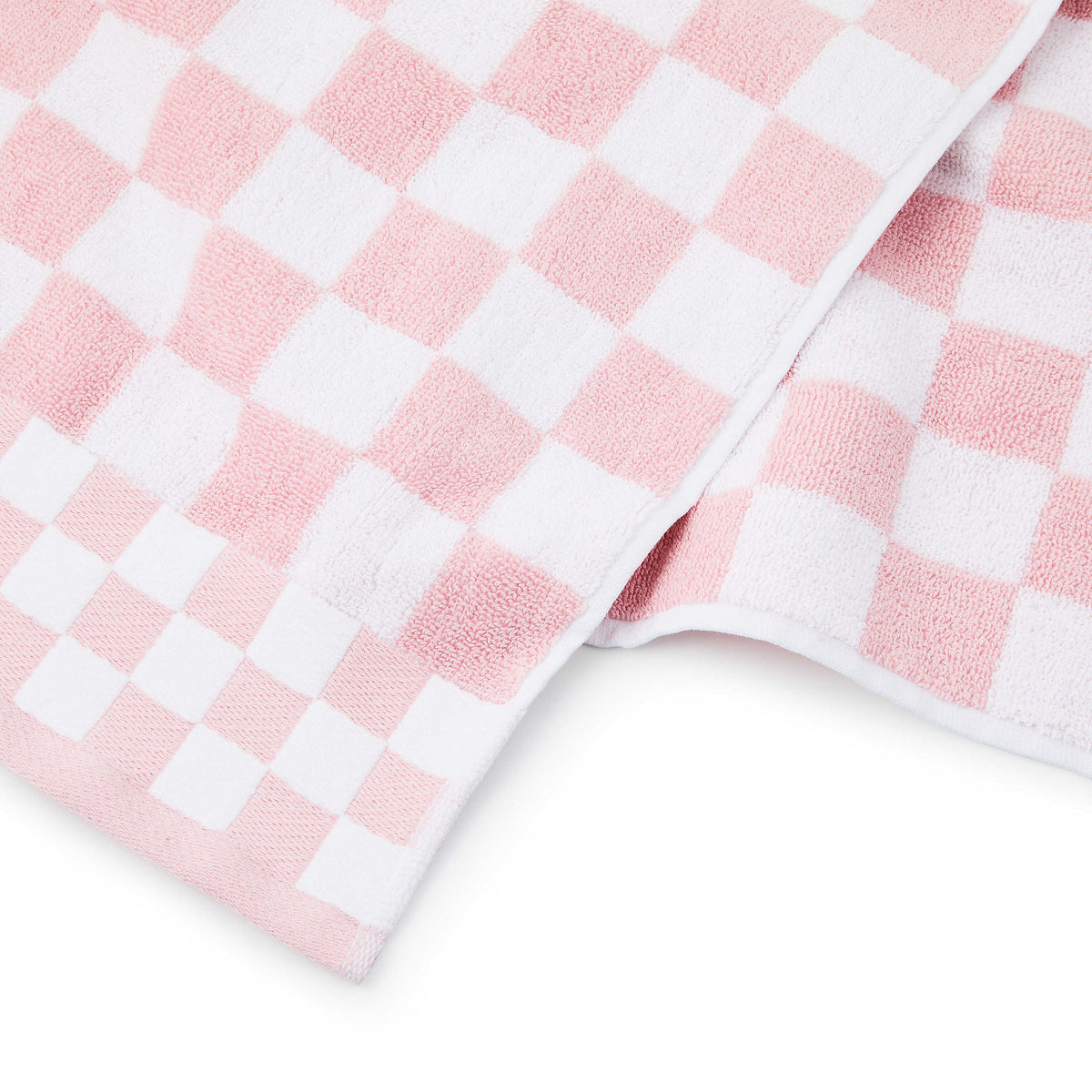 Pink check bath towel made of cotton terrycloth with a matching border trim.