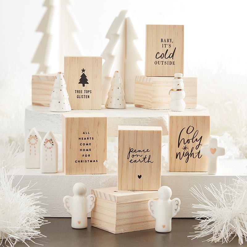 Ceramic figurines and pine wood boxes with holiday phrases on a tiered display.
