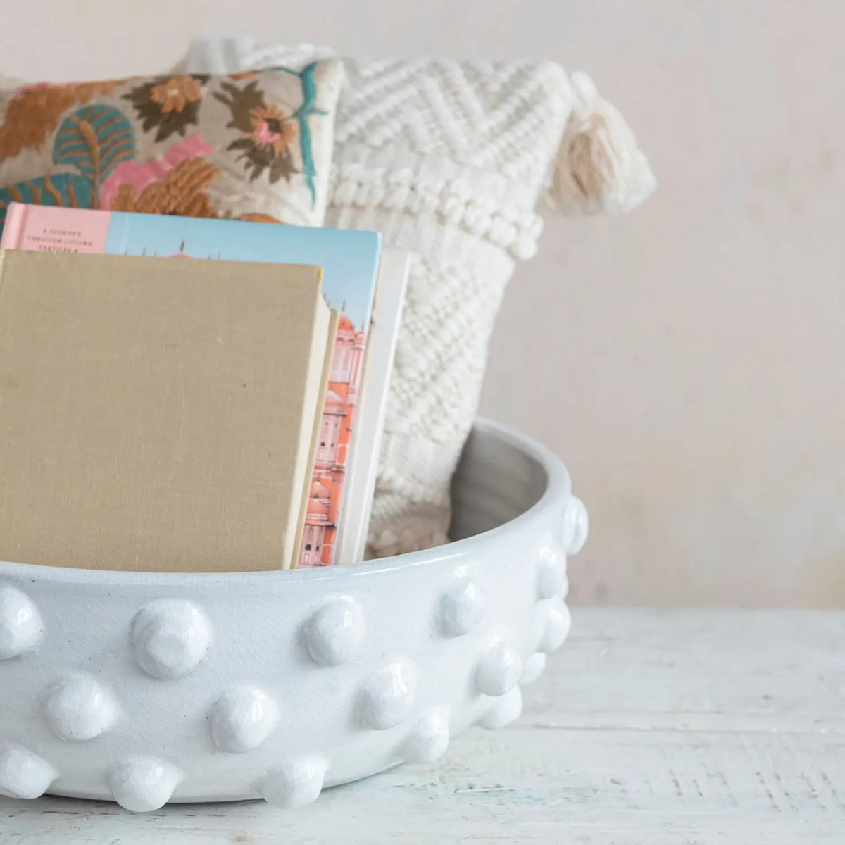 Round terracotta bowl with crackle glaze finish featuring raised dot pattern on rim.