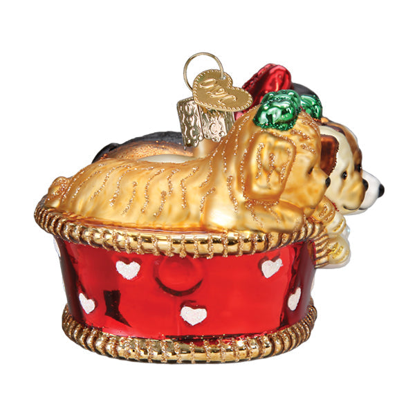 Glass Christmas ornament featuring three puppies sitting in a red basket decorated with hearts.