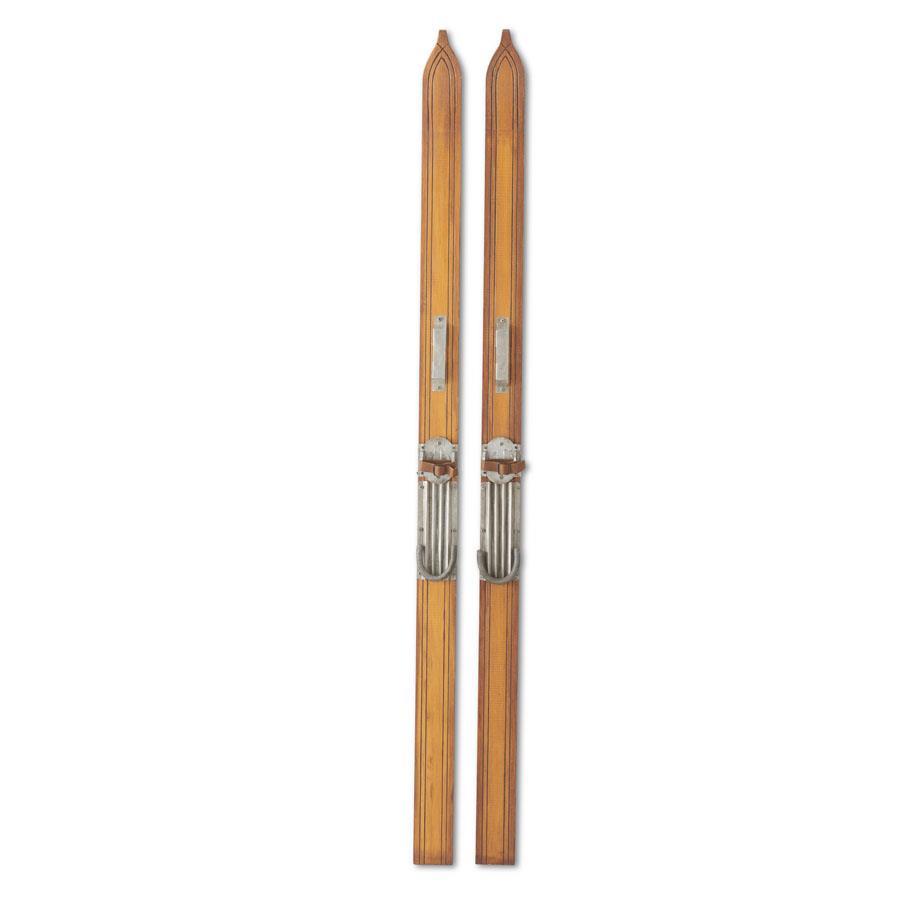 Pair of decorative wooden pine skis standing upright with a natural wood grain finish.