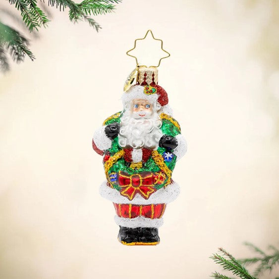Wreath Wrangler Claus Gem glass Christmas ornament featuring Santa holding a festive green wreath.
