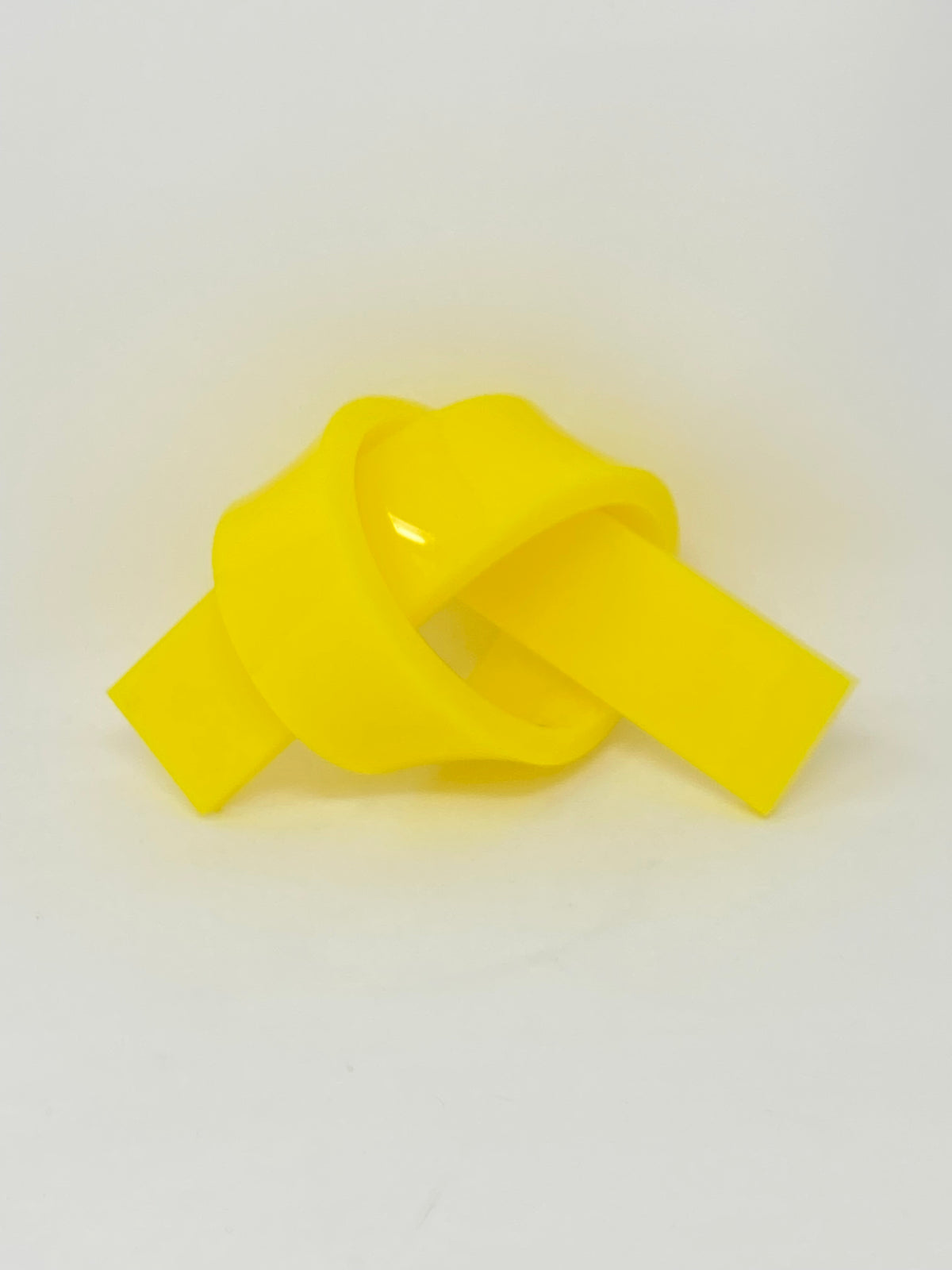 Acrylic knot pendant on a chain with dimensions 3/8 inch by 1-1/2 inches.