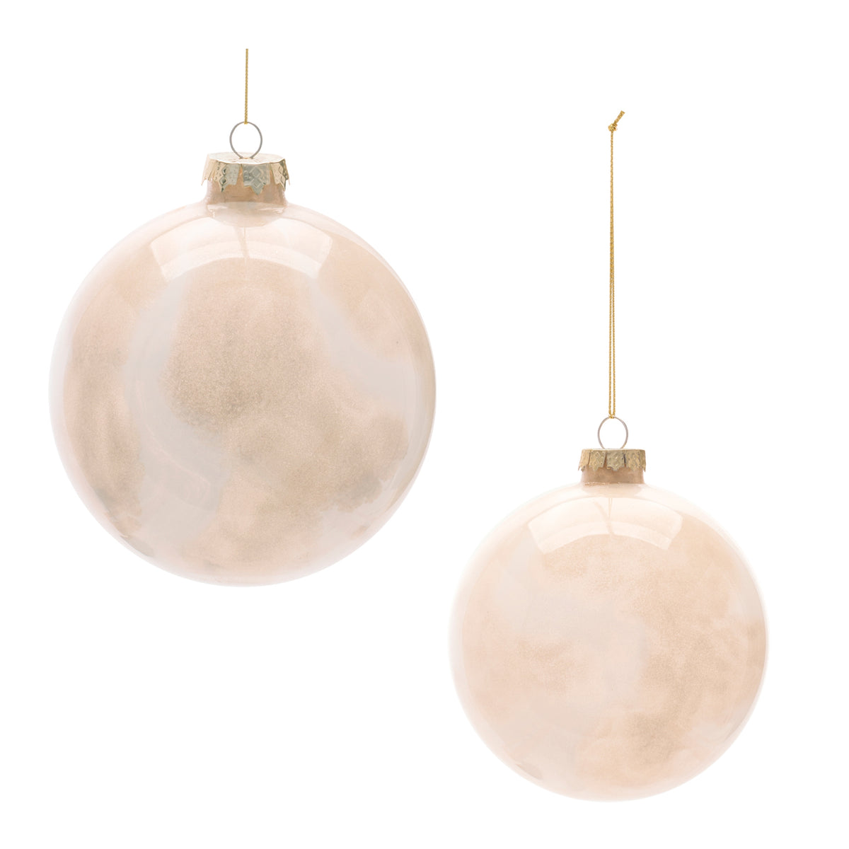 Two round glass ball ornaments in a soft champagne pink color with gold hanging strings.