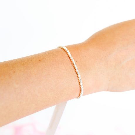 Silver beaded bracelet featuring a delicate chain link design with small metallic beads.