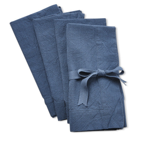 Set of four blue slub-textured fabric napkins, one tied with a matching ribbon bow.
