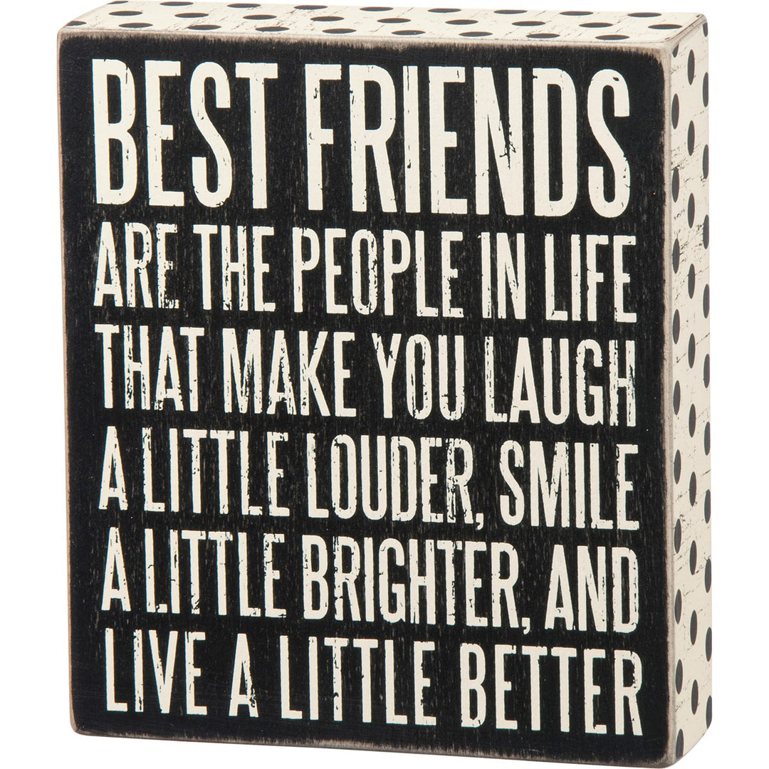 Black wooden box sign with white text reading 'BEST FRIENDS ARE THE PEOPLE IN LIFE THAT MAKE YOU LAUGH A LITTLE LOUDER, SMILE A LITTLE BRIGHTER, AND LIVE A LITTLE BETTER'.