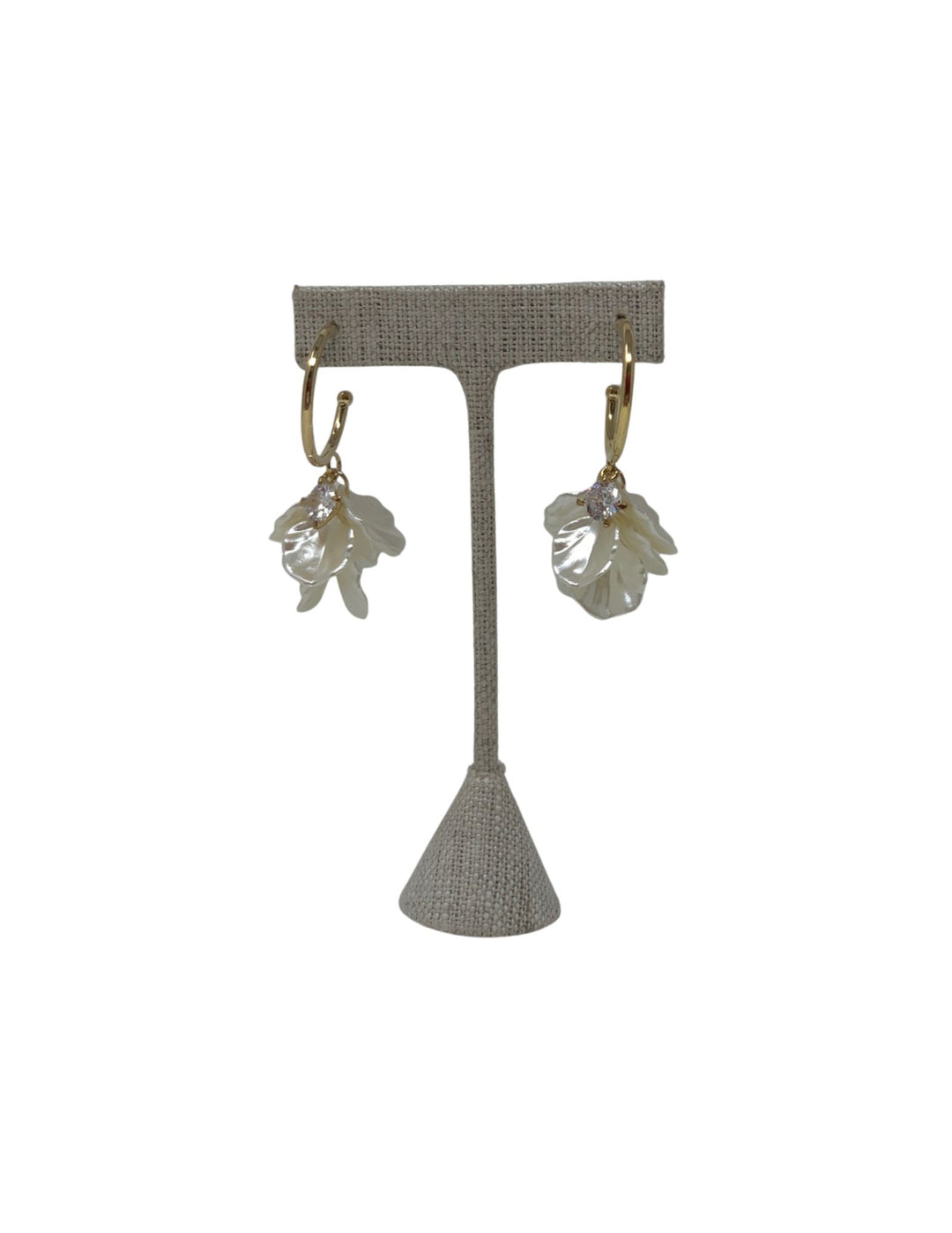 Gold hoop earrings featuring white flower petal charms and a central sparkling crystal.