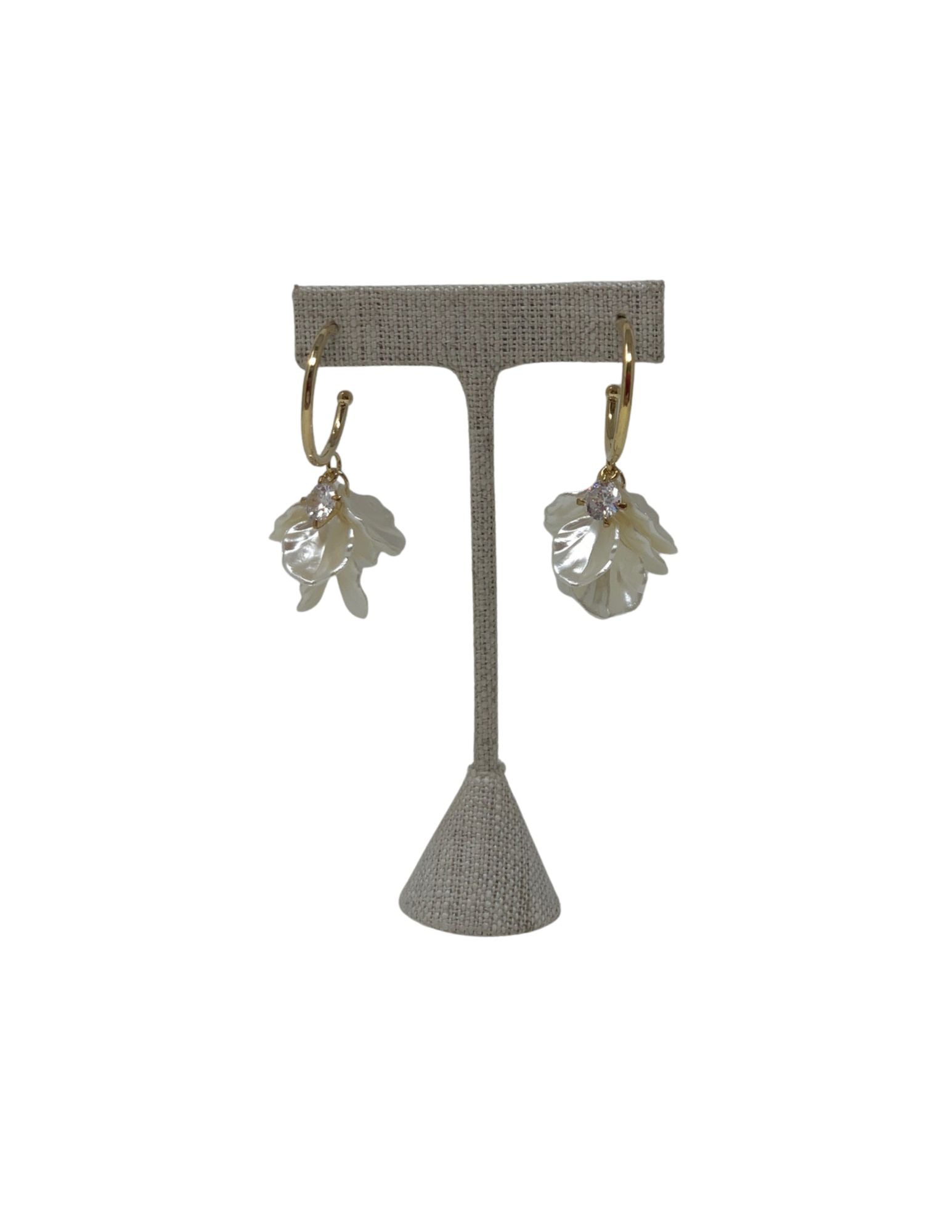 Gold hoop earrings featuring white flower petal charms and a central sparkling crystal.
