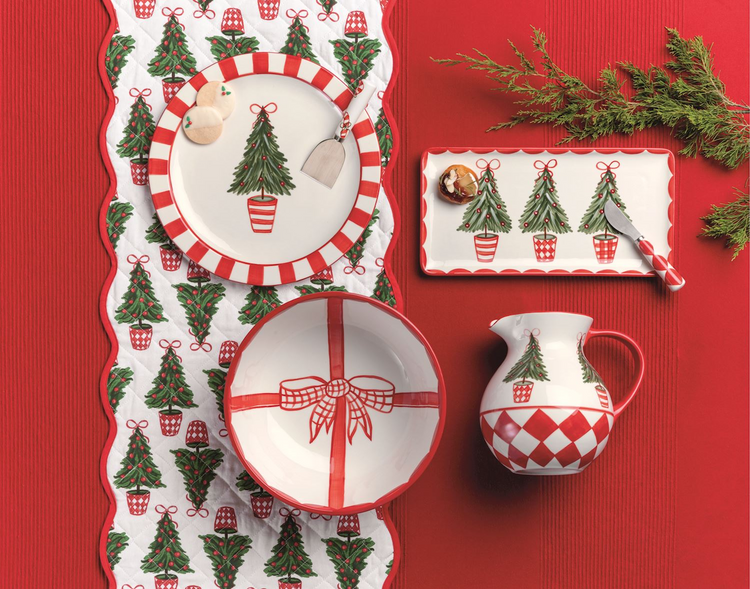 Quilted white table runner with red scalloped edges and a festive Christmas tree pattern.