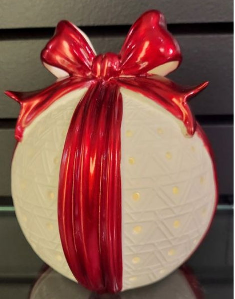 Translucent porcelain sphere with a metallic red bow and ribbon, featuring a glowing dot pattern.