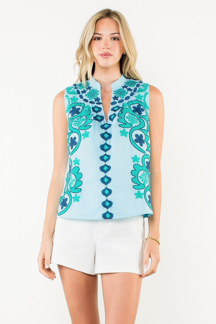 Woman wearing the Ellie Sleeveless Embroidered Top in light blue with teal floral embroidery.
