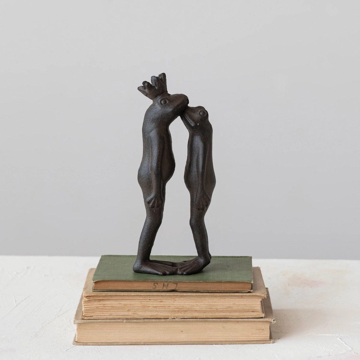 Cast iron kissing frog prince figurine in dark finish with detailed sculpted features.