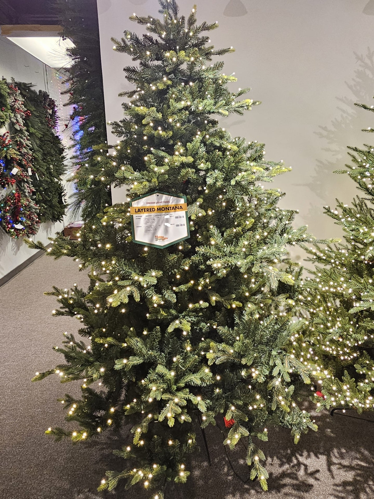 7.5' Layered Montana Christmas tree with warm white finger light LEDs and dense green needles.