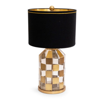 Golden Gambit table lamp with glass base over brass, gold hardback drum shade, and braided trim.