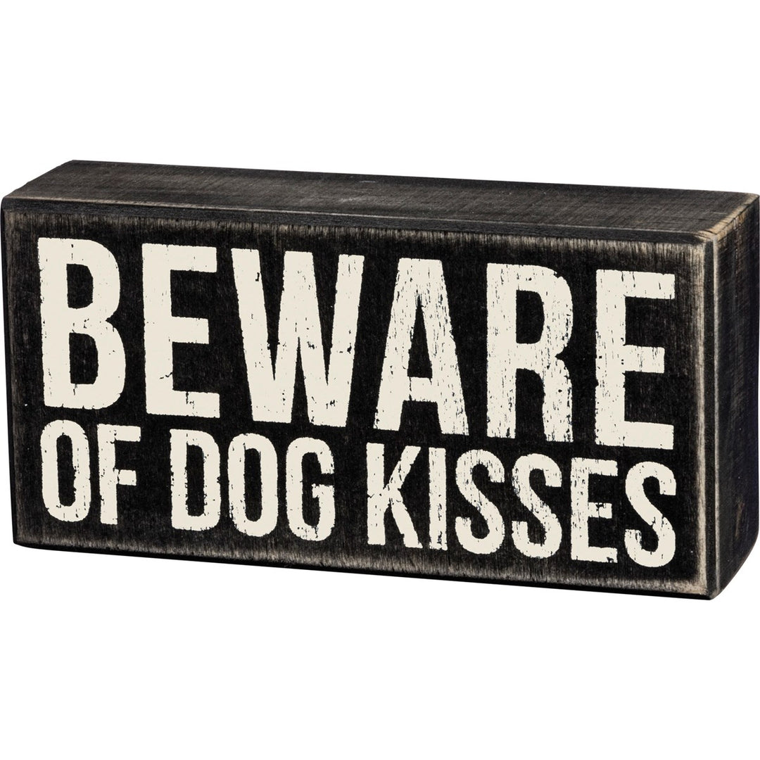 Black wooden box sign with distressed white text reading "BEWARE OF DOG KISSES".