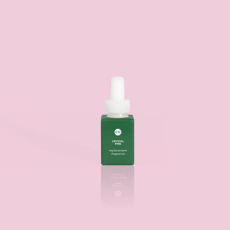 CB+ Pura Diffuser Refill in Crystal Pine, a small green bottle with a white cap on a pink background