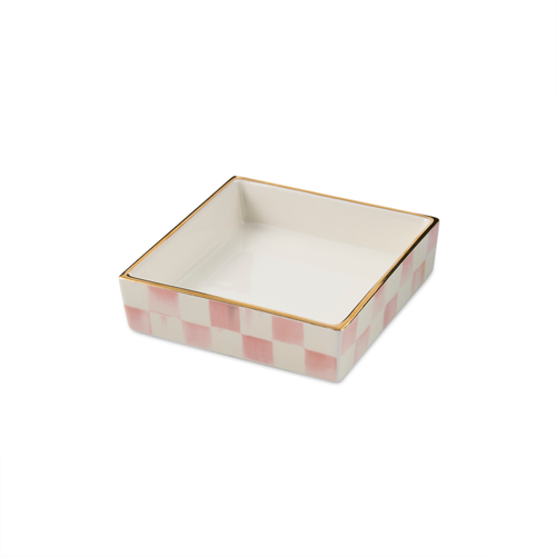Square ceramic cocktail napkin holder with a pink and white checkered pattern and gold rim.