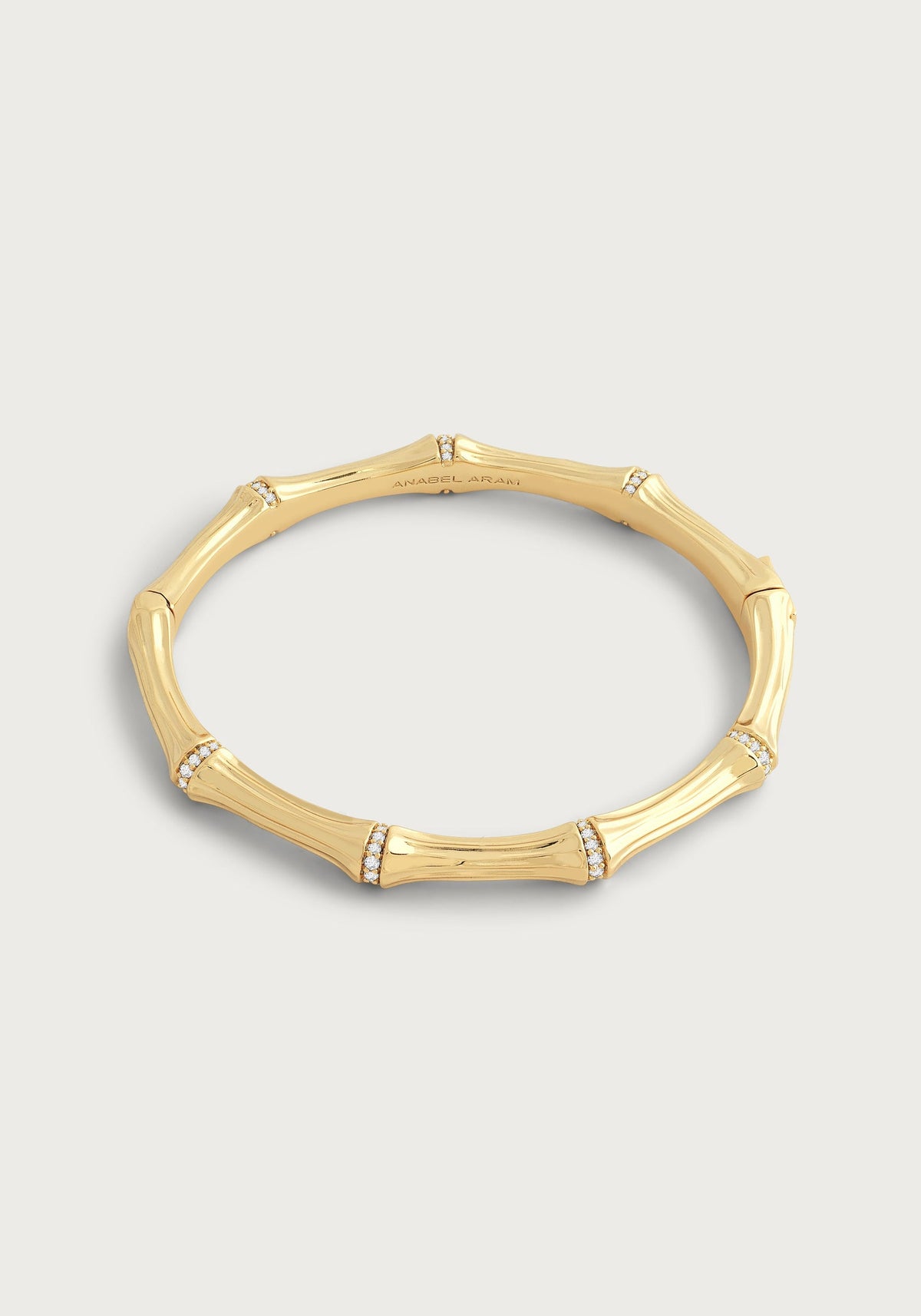 Gold-plated bamboo-shaped hinged bangle with crystal pavé accents on each segment.
