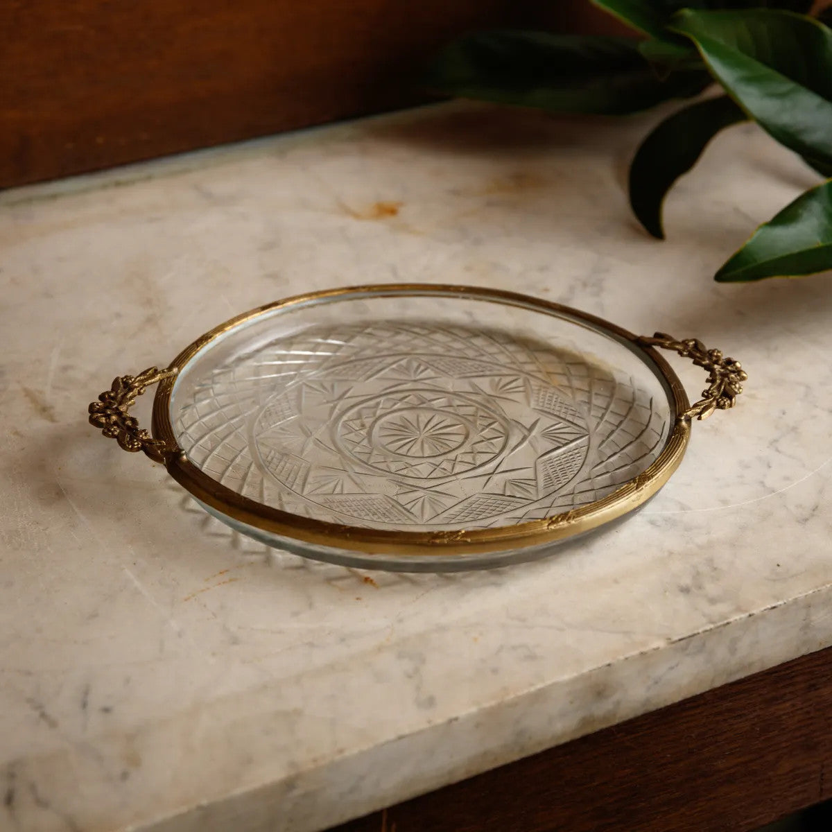 Brass tray with glass insert featuring a lady's maid silhouette in black against a light background.