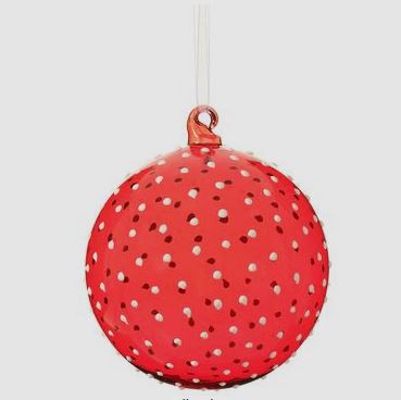 Red glass ball ornament with white paint dots on a clear spherical surface.